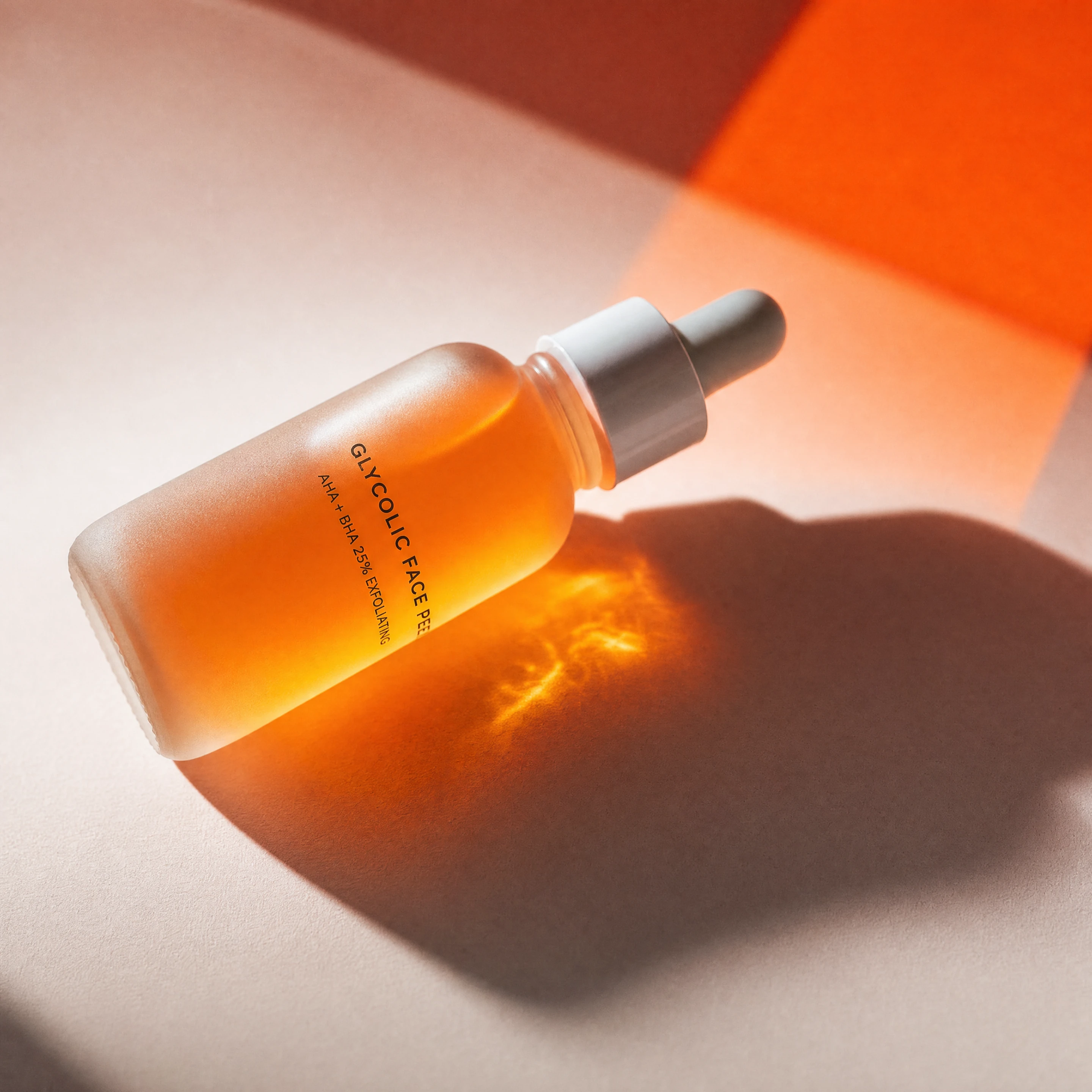 Orange glycolic face peel dropper bottle in hard studio light
